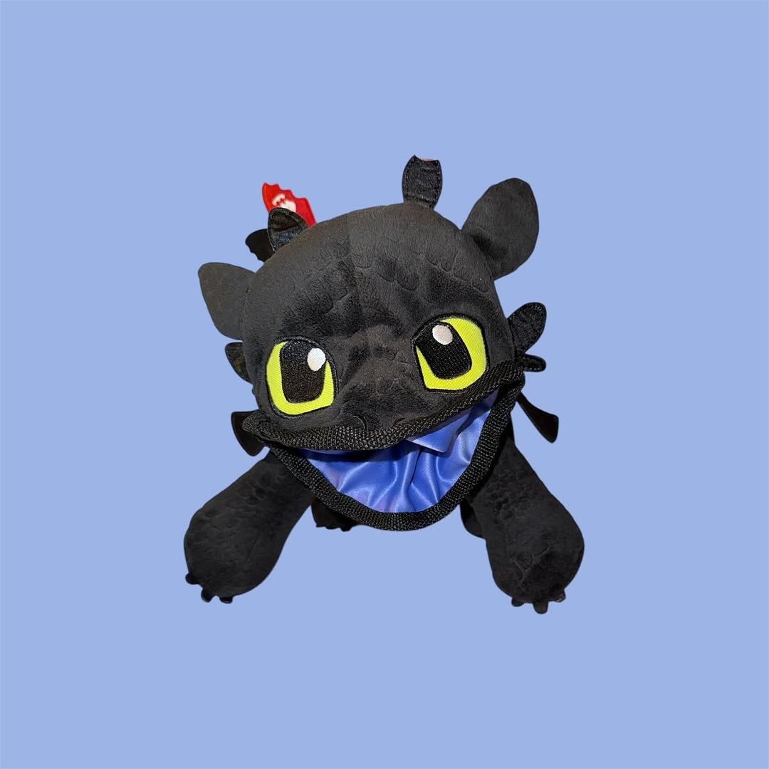 Chalk Bag Plush toy resembling a dragon with large eyes and a blue interior on a light blue background