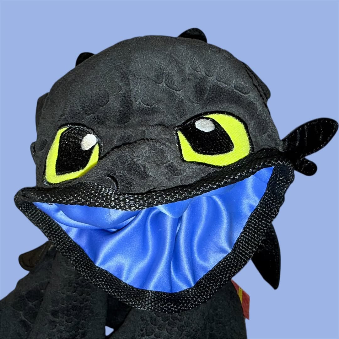 Chalk Bag Plush toy resembling a dragon with large eyes and a blue interior on a light blue background