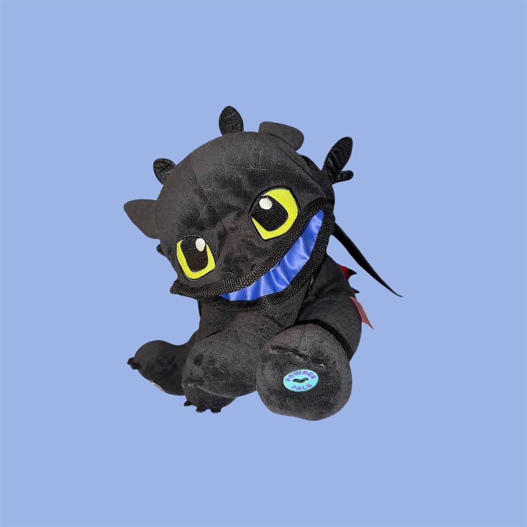 Chalk Bag Plush toy resembling a dragon with large eyes and a blue interior on a light blue background